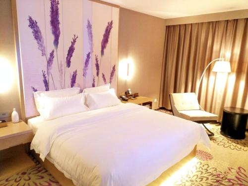 a bedroom with a large white bed and a chair at Lavande Hotel Jinan Second Ring East Road Quanfu Overpass Branch in Jinan