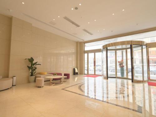 a lobby with a table and chairs in a building at Lavande Hotel(Macheng High-speed Station Branch) in Macheng