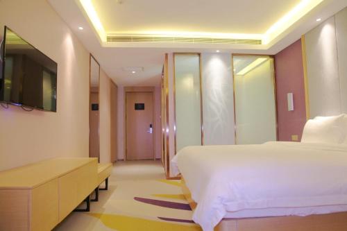 a bedroom with a large white bed and a television at Lavande Hotel (Harbin Ice and Snow World University of Commerce Branch) in Harbin