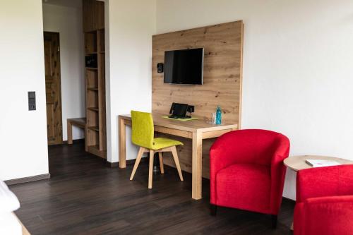 a hotel room with a desk and two chairs at Gasthof Spelsberg in Altena
