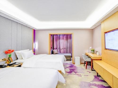 a hotel room with three beds and a flat screen tv at Lavande Hotel (Shenyang Olympic Center Wanda Branch) in Shenyang