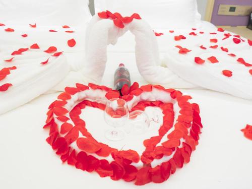 a heart wreath on a bed with a wine glass at Lavande Hotel(Macheng High-speed Station Branch) in Macheng