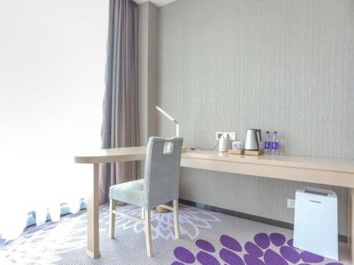 a desk in a room with a chair and a table at Lavande Hotel Shijiazhuang Zhonghua North Street Zhongchu Plaza Branch in Shijiazhuang