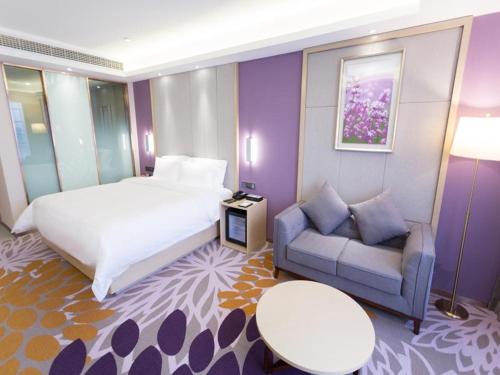 um quarto de hotel com uma cama e um sofá em Lavande Hotel Suqian Yanghe New District em Suqian