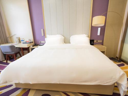 a large white bed in a hotel room at Lavande Hotel(Macheng High-speed Station Branch) in Macheng