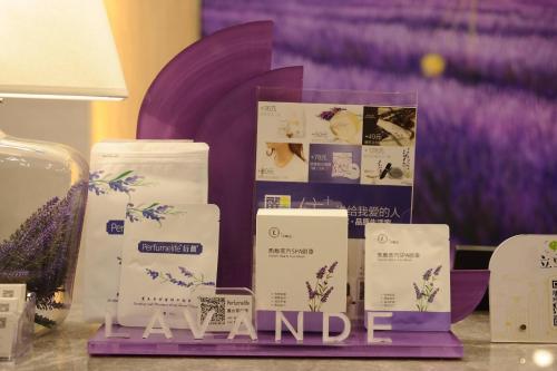 a display of towels on a table with a purple wall at Lavande Hotel Linyi People's Square Branch in Linyi