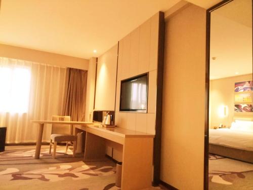 a hotel room with a desk and a bed at Lavande Hotel Jinan Second Ring East Road Quanfu Overpass Branch in Jinan