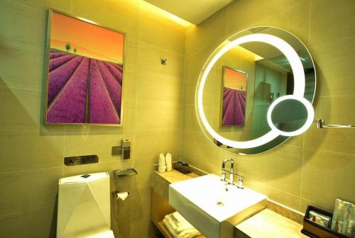 een badkamer met een wastafel en een spiegel bij Lavande Hotel Wuhan Xudong Branch in Wuhan