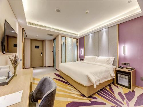 a bedroom with a large bed and a tv in it at Lavande Hotel Tangshan Convention and Exhibition Yuanyang City in Tangshan