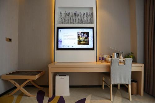 a computer desk with a computer monitor and a chair at Lavande Hotel Shijiazhuang Zhonghua North Street Zhongchu Plaza Branch in Shijiazhuang