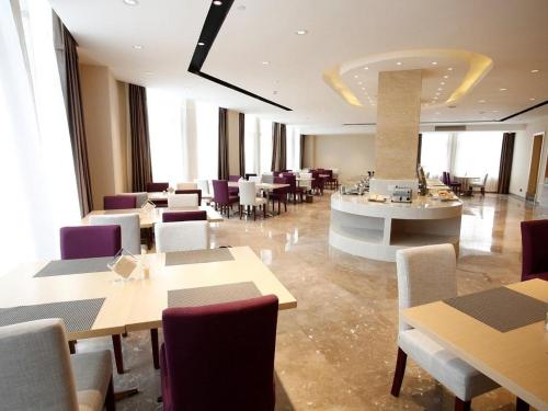 un restaurante con mesas y sillas en una habitación en Lavande Hotel Jiujiang Jiujiang College, en Jiujiang