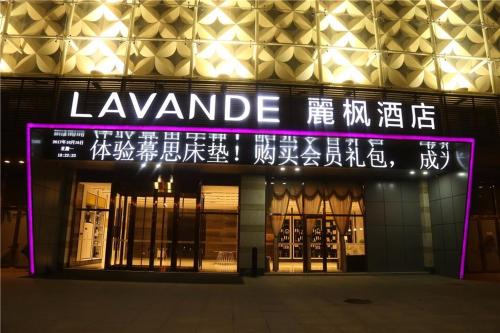 a building with a lit up sign in front of it at Lavande Hotel Shijiazhuang Zhonghua North Street Zhongchu Plaza Branch in Shijiazhuang