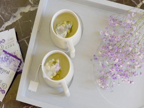 two cups of soup on a tray with flowers at Lavande Hotel Changchun Hangkong University Fanrong Road Metro Station in Changchun