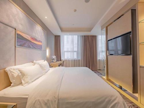 a bedroom with a large bed with a flat screen tv at Lavande Hotel Ningbo Railway Station Branch in Ningbo