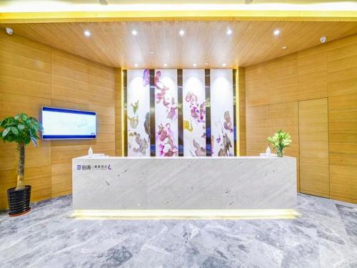 a lobby with a reception desk in a building at Lavande Hotel (Shenyang Olympic Center Wanda Branch) in Shenyang