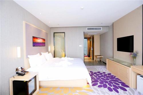a bedroom with a large bed and a flat screen tv at Lavande Hotel Shijiazhuang Zhonghua North Street Zhongchu Plaza Branch in Shijiazhuang