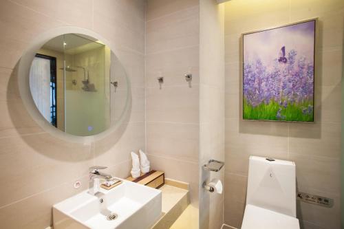 a white bathroom with a sink and a mirror at Lavande Hotel Xuzhou West Exit of High Speed Rail Station Branch in Xuzhou