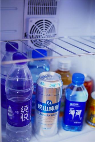 a refrigerator filled with bottles of water and condiments at Lavande Hotel Shijiazhuang Zhonghua North Street Zhongchu Plaza Branch in Shijiazhuang