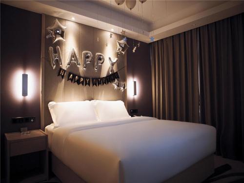 a bedroom with a bed with a happy new year sign on the wall at Lavande Hotel Qiqihar Supervisory Office in Qiqihar
