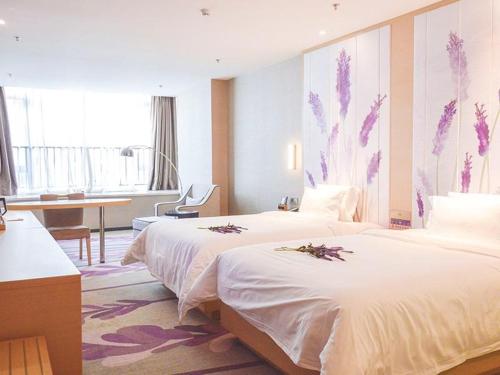 徐州市にあるLavande Hotel Xuzhou New Town Midea Plazaのベッド2台とデスクが備わるホテルルームです。