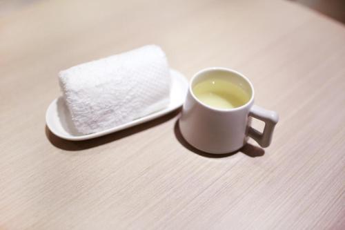 a cup of tea and a plate with a napkin at Lavande Hotel (Jingdezhen Taoxichuan Creative Square Branch) in Jingdezhen