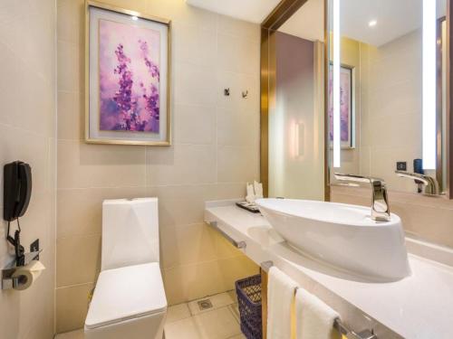 a white bathroom with a sink and a mirror at Lavande Hotel Langfang City Government in Langfang