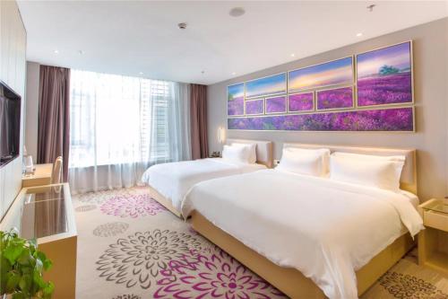 a hotel room with two beds and a tv at Lavande Hotel Rizhao Rong'an Square Wanda Movie Theater Branch in Rizhao