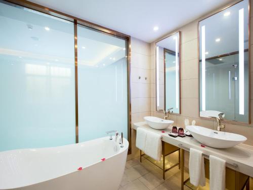 La salle de bains est pourvue de 2 lavabos et d'une baignoire. dans l'établissement Lavande Hotel (Yingtan Longhushan Avenue Branch), à Yingtan