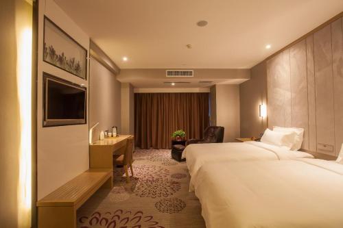 a hotel room with two beds and a desk at Lavande Hotel Xuzhou West Exit of High Speed Rail Station Branch in Xuzhou