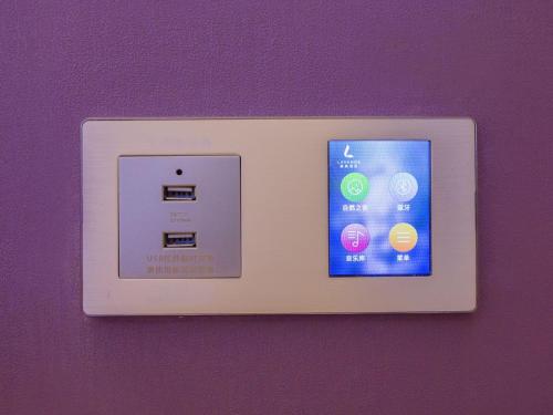 a lightswitch with an iphone on a purple wall at Lavande Hotel (Zibo Beijing Road Huaqiao Building Branch) in Zibo