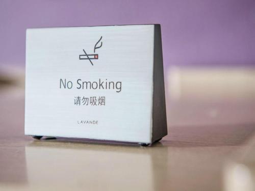 a no smoking sign sitting on top of a table at Lavande Hotel Jinzhou Jiefang Road Kaixuan Building in Jinzhou