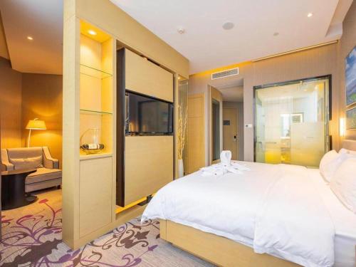 a bedroom with a large white bed and a couch at Lavande Hotel Ningbo Railway Station Branch in Ningbo