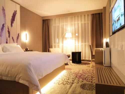 a hotel room with a bed and a flat screen tv at Lavande Hotel Jinan Second Ring East Road Quanfu Overpass Branch in Jinan