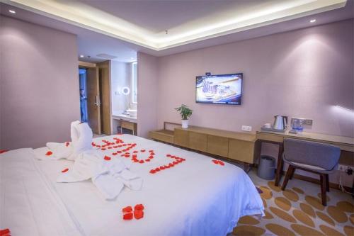una camera d'albergo con un grande letto bianco e decorazioni rosse di Lavande Hotel (Nanchang Qingshan Lake High-tech Branch) a Nanchang