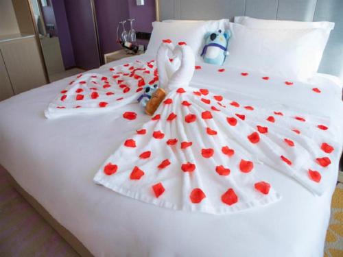 a bed with a swan in a dress of hearts at Lavande Hotel Jinzhou Jiefang Road Kaixuan Building in Jinzhou