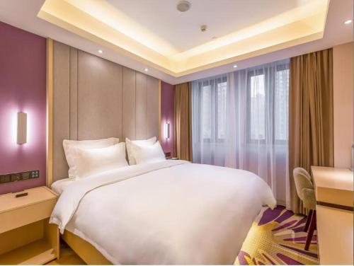 a bedroom with a large white bed and a desk at Lavande Hotel Langfang City Government in Langfang