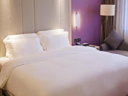a large white bed in a hotel room at Lavande Hotel (Changsha Railway Station Branch) in Changsha