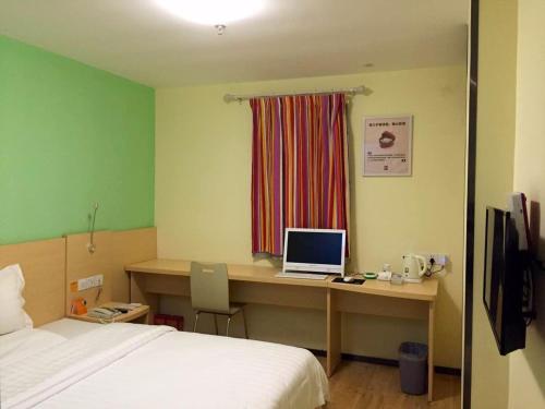 a bedroom with a desk with a laptop computer on it at 7Days Inn Bijie Zhijin Chengguan in Zhijin