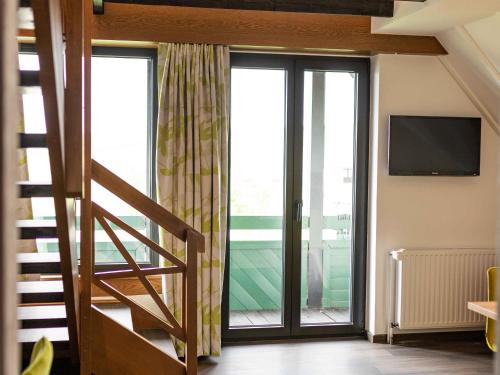 a room with a staircase and a large window at Gasthof Spelsberg in Altena
