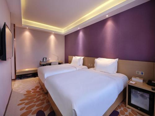 a hotel room with two beds and a flat screen tv at Lavande Hotel (Harbin Ice and Snow World University of Commerce Branch) in Harbin