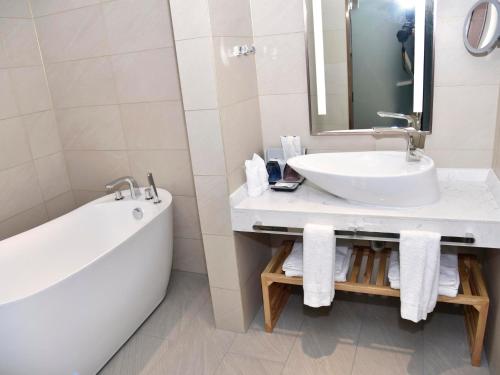 a bathroom with a tub and a sink and a bath tub at Lavande Hotel Fuzhou Wanda Plaza High-speed Railway Station in Fuzhou