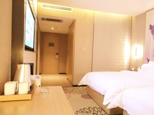 a bedroom with a bed and a table with a lamp at Lavande Hotel Jinan Second Ring East Road Quanfu Overpass Branch in Jinan