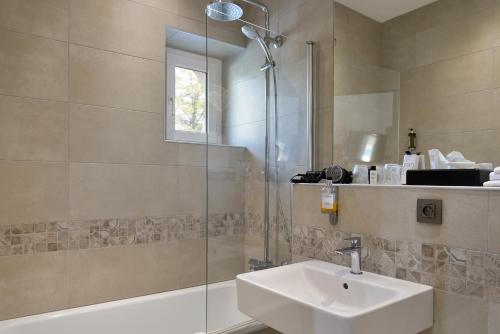 W łazience znajduje się umywalka i prysznic. w obiekcie Logis Domaine De Valaudran w mieście Salbris