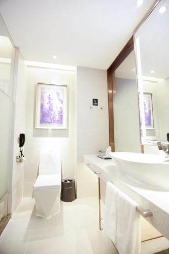 a white bathroom with a sink and a toilet at Lavande Hotel (Jingdezhen Taoxichuan Creative Square Branch) in Jingdezhen