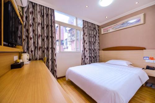 - une chambre avec un lit blanc et une fenêtre dans l'établissement 7Days Inn Chongqing Changshou Changshou Road, à Changshou