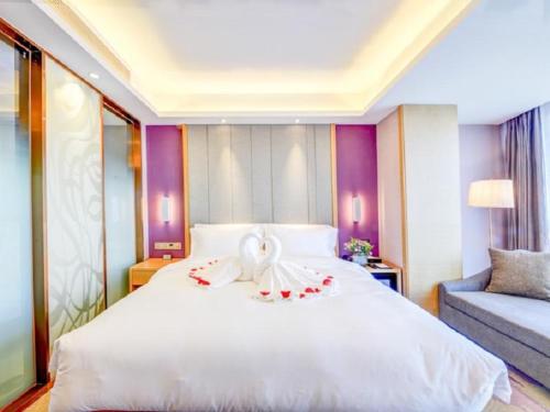 a bedroom with a large white bed with flowers on it at Lavande Hotel (Shenyang Olympic Center Wanda Branch) in Shenyang