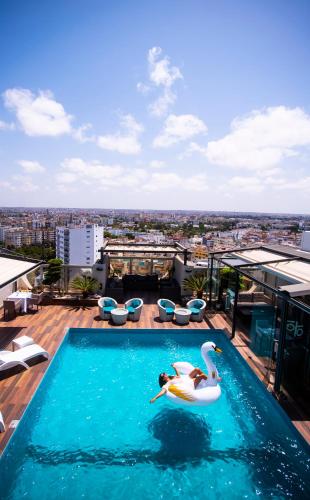 a swimming pool with two swans on a building at Mövenpick Hotel Casablanca in Casablanca