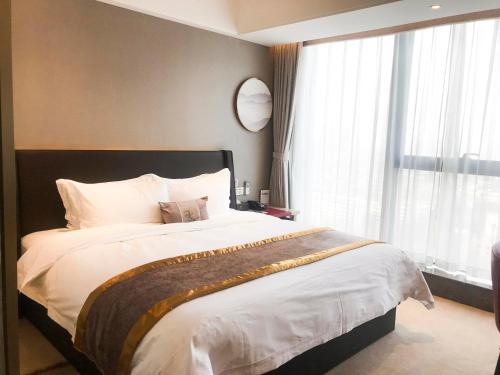 a bedroom with a large bed with a large window at Lavande Hotel Shijiazhuang Zhonghua North Street Zhongchu Plaza Branch in Shijiazhuang