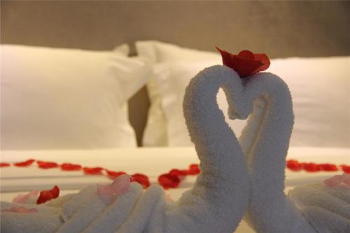 a cake shaped like swans on a bed at Lavande Hotel Rizhao Rong'an Square Wanda Movie Theater Branch in Rizhao