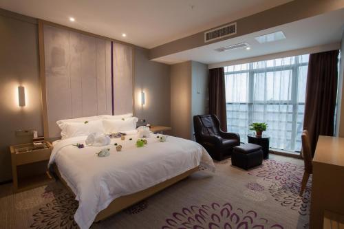 una habitación de hotel con una cama grande y una silla en Lavande Hotel Xuzhou West Exit of High Speed Rail Station Branch en Xuzhou